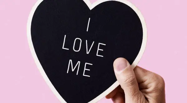 Dłoń trzyma serce z napisem "I LOVE ME". To jak piękne krótkie wiersze o miłości, zaczynające się od siebie.