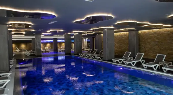 Nowoczesny basen w hotelu dla dorosłych w Polsce. Luksusowe leżaki i nastrojowe oświetlenie tworzą idealną atmosferę relaksu.
