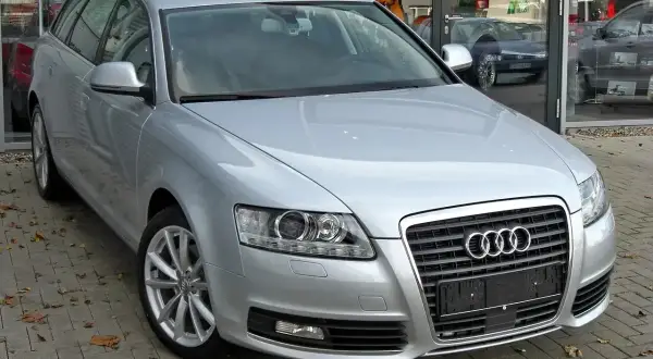 Srebrne Audi A6 C6 2.7 TDI Avant zaparkowane przed salonem.