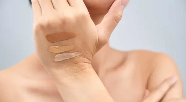 Tre campioni di fondotinta su una mano, utili per capire come scegliere il sottotono della pelle.