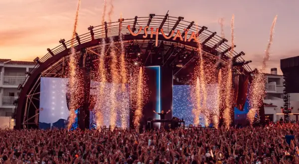 Un'esplosione di fuochi d'artificio illumina il palco di Ushuaïa Ibiza, dove un DJ incanta la folla. Un evento indimenticabile!