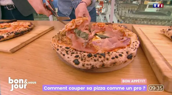 Une pizza al taglio généreuse, garnie de jambon cru et de basilic, est coupée avec des ciseaux. Un chef montre comment la découper comme un pro.