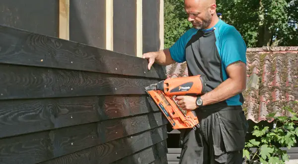 Man monterar liggande panel med spikpistol.