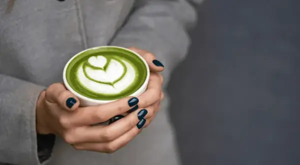Zielone matcha latte z pianką w kształcie serca. Idealne co zamiast kawy na pobudzenie, gdy potrzebujesz energii i spokoju.