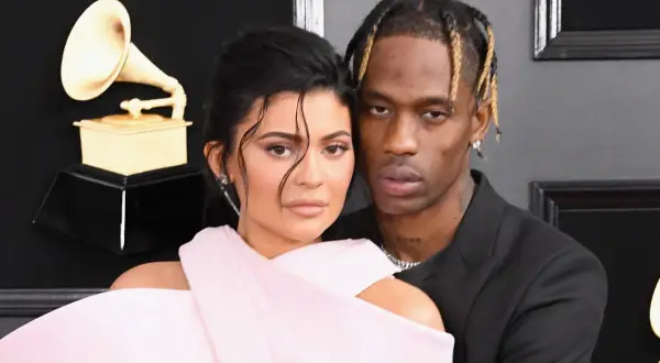 Kylie Jenner i Travis Scott na gali Grammy, blisko siebie, z Grammy w tle.