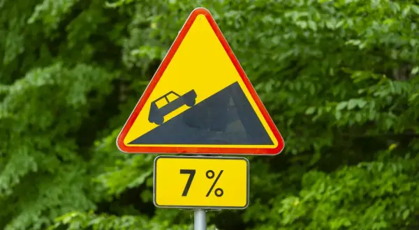 Znak ostrzegawczy: strome zbocze, nachylenie 7%. Jak elektroda dodatnia, która kieruje prąd w górę, tak i ten znak ostrzega przed stromym podjazdem.