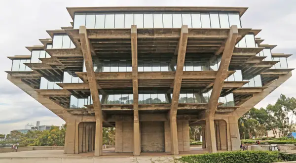 The Geisel Library, a famous brutalist architecture masterpiece, features stacked concrete levels with glass windows, resembling a Mayan pyramid.