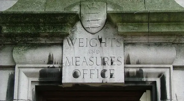 Napis "Weights and Measures Office" nad drzwiami, symbolizuje miarę długości w Anglii.