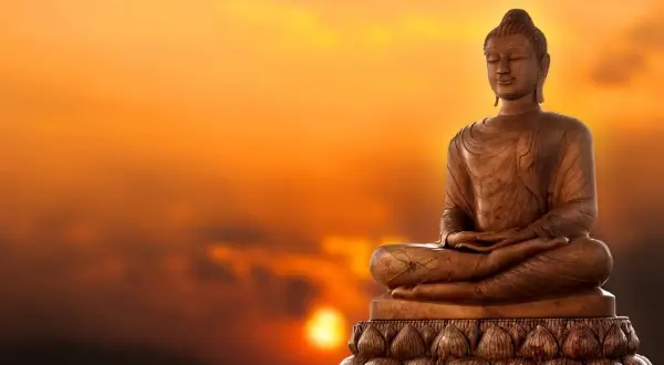 Buddha-staty i solnedgången. Lär dig fakta om buddhismen och dess symbolik.
