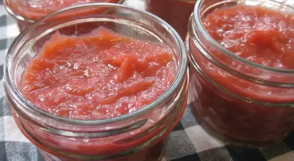 Fyra små glasburkar fyllda med hemgjord rabarbermarmelad. Perfekt för frukostmackan eller till desserten.