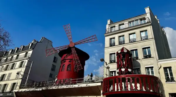 Słynny czerwony wiatrak Moulin Rouge na tle błękitnego nieba.