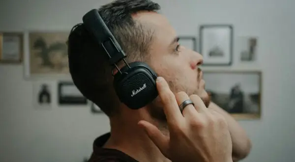 Mężczyzna w słuchawkach Marshall, skupiony na dźwiękach 432 hz.