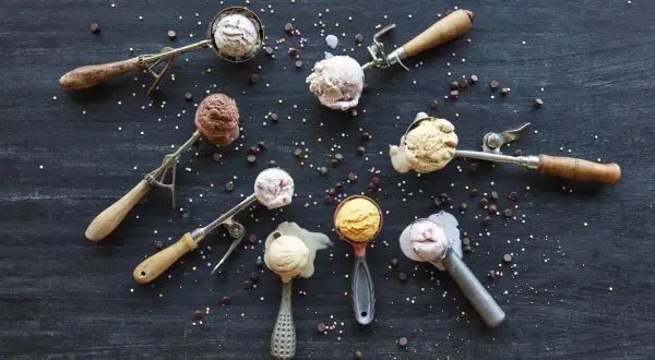 Verschiedene Eissorten in Eislöffeln, bereit zum Servieren. Perfekt, um eis selber machen zu wollen! Bunt bestreut mit Schokostückchen und Streuseln.