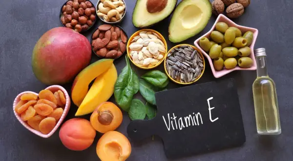 Vielfalt an vitamin e lebensmittel: Nüsse, Samen, Avocado, Mango, Spinat, Oliven, Aprikosen und Öl.
