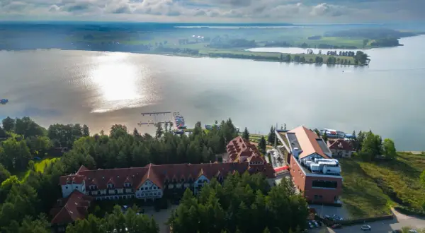Hotel Robert's Port Lake Resort & Spa na Mazurach, z widokiem na jezioro i przystań. Warto sprawdzić opinie przed rezerwacją.
