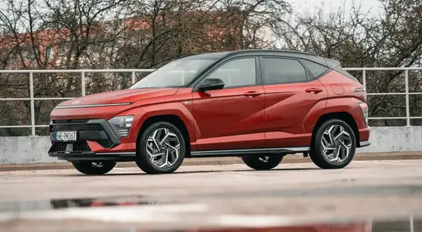 Czerwony Hyundai Kona Hybrid, idealny do miasta, z niskim spalaniem. Stylowy SUV na mokrej nawierzchni.
