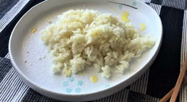 Piatto di riso in bianco, semplice e profumato, pronto per essere gustato con le bacchette.