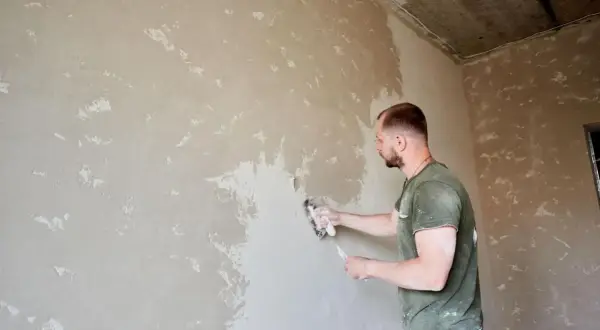 Budowlaniec nakłada tynk cementowo-wapienny. Czy trzeba go szpachlować? Zależy od efektu końcowego.