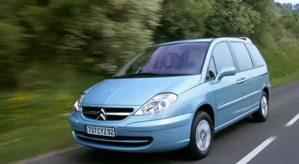 La Citroën C8, con i suoi interni spaziosi, sfreccia su una strada panoramica.