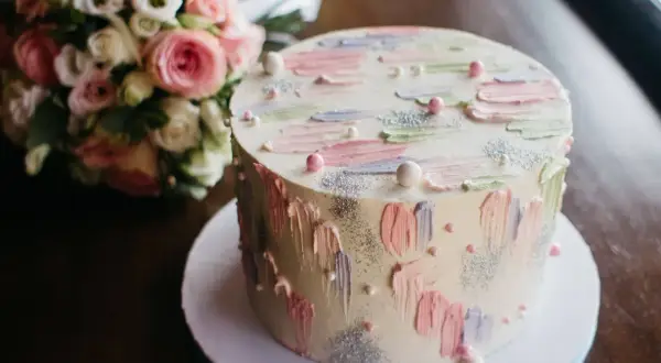 Oto tort weselny z pastelowymi pociągnięciami pędzla i brokatem. Trudno zgadnąć, ile waży tort, ale wygląda na pyszny!