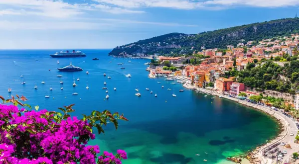Bunte Küstenstadt mit Yachten im azurblauen Meer. Ein perfektes Bild für die besten Reiseziele im September weltweit.