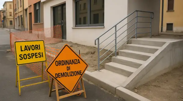 Segnali stradali indicano "Lavori sospesi" e "Ordinanza di demolizione" davanti a un cantiere. L'edilizia libera è ferma.