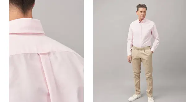 Uomo con abito blu e camicia rosa, un look elegante e moderno.