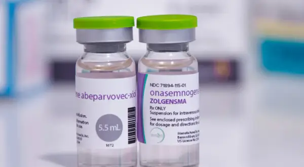 Dwie fiolki leku Zolgensma (onasemnogene abeparvovec) na białym tle.