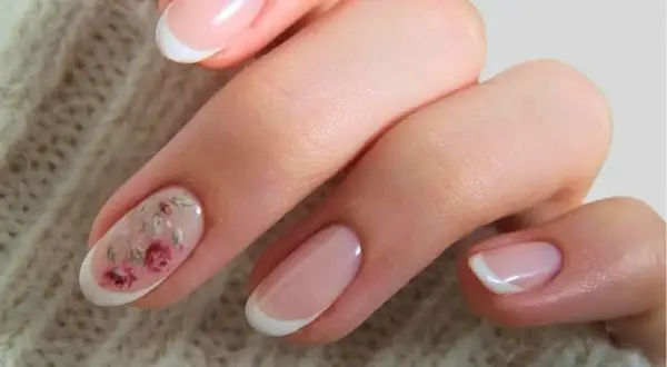 Delikatne paznokcie boho z subtelnym motywem kwiatowym na jednym z paznokci. Klasyczny french manicure w letnim wydaniu.