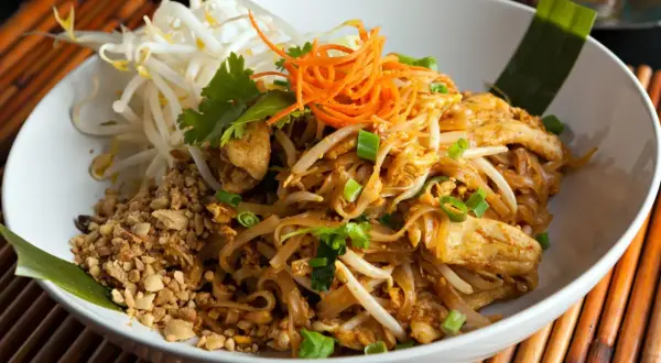 Pyszne danie co to pad thai: makaron ryżowy z kurczakiem, kiełkami fasoli mung, orzeszkami ziemnymi i szczypiorkiem.