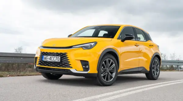 Żółty, kompaktowy SUV, który może być najmniejszym Lexusem, stoi na drodze.