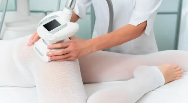 Zabieg endermologii na uda. Kiedy efekty? Widoczna głowica urządzenia masująca skórę przez specjalną odzież.