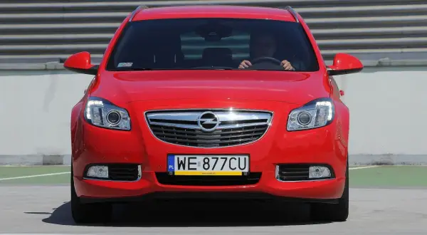 Czerwony Opel Insignia z tablicą WE 877CU. Poznaj jego imponujące opel insignia wymiary i styl.