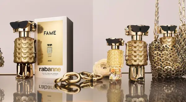 Złote flakony perfum FAME od Rabanne, ozdobione łuskami, przyciągają wzrok. Luksusowy dodatek dla każdej kobiety.