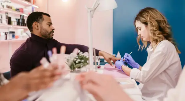 Mann lässt sich im Nagelstudio die Nägel machen. Ein Kleingewerbe wie dieses unterliegt der IHK-Pflicht.