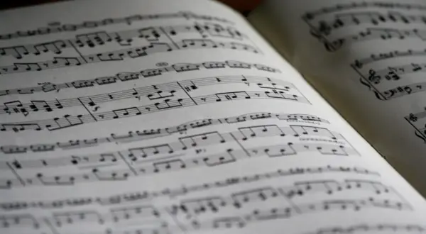 Otwarta księga nut, z nutami i znakami muzycznymi. Widać fragmenty z dynamiką, sugerujące glissando w muzyce.