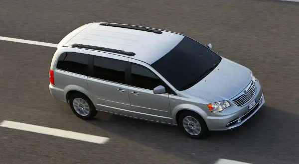 Srebrny Lancia Voyager jedzie po autostradzie.