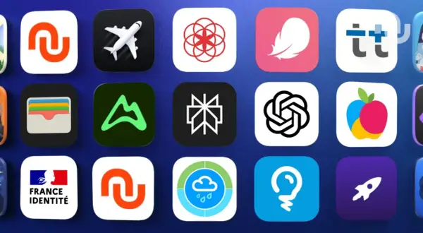 Grille d'icônes d'applications, incluant un avion, un portefeuille, un logo de montagne, et des symboles abstraits. Une mise à jour des applications est en cours.