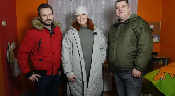 Trzy osoby stoją w pokoju. Mężczyzna w czerwonej kurtce, kobieta w szarej i mężczyzna w zielonej. To nasz nowy dom, Arek nie żyje.
