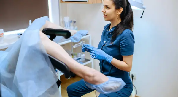 Lekarka z kolposkopem w ręku wyjaśnia pacjentce, dlaczego cytologia boli.