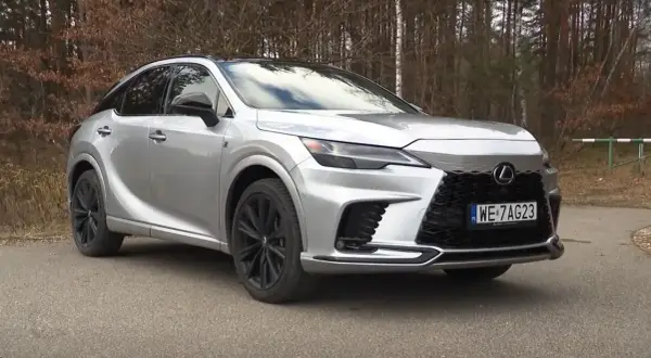 Srebrny Lexus RX500 z czarnymi felgami na tle lasu.