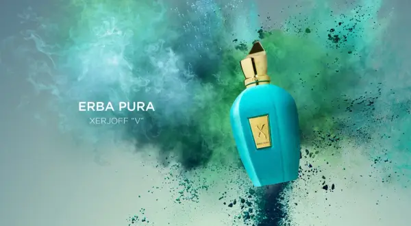 Turkusowa butelka perfum Erba Pura Xerjoff "V" na tle eksplozji zielonych i niebieskich pyłów.