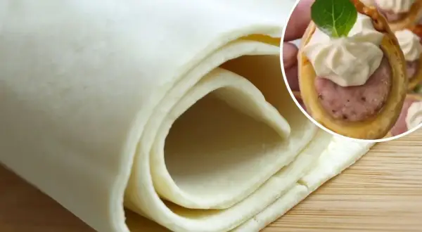 Ciasto francuskie zwinięte w rolkę i małe przekąski z kiełbasą w cieście francuskim.