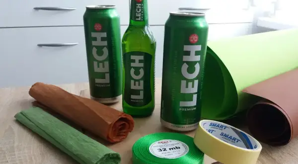 Jak zrobić prezent z piwa? Potrzebne będą puszki i butelka piwa Lech, ozdobny papier, wstążka i taśma.