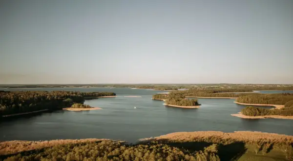 Malowniczy krajobraz z licznymi wyspami i lasami otaczającymi spokojne wody jeziora Kisajno.