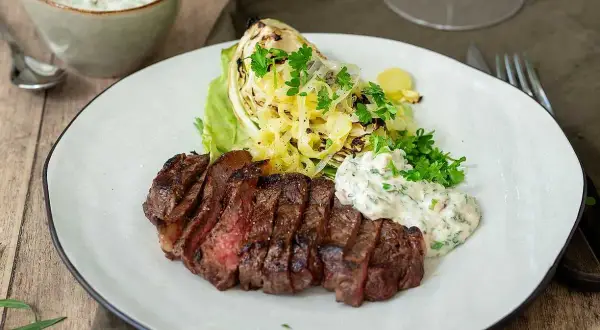 Perfekt grillad ryggbiff med krispig kål och en krämig sås. En härlig måltid att grilla ryggbiff till.
