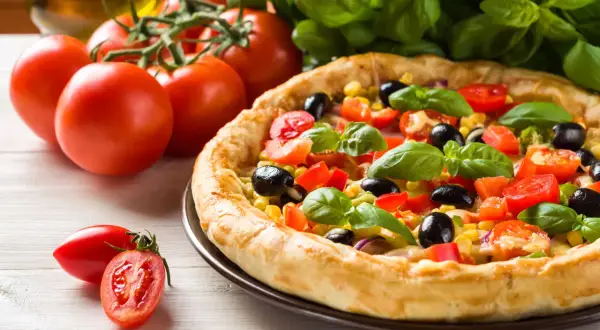 Pyszna pizza z pomidorami, oliwkami i kukurydzą. Idealna na szybki obiad, a czas pieczenia to klucz do jej doskonałości.