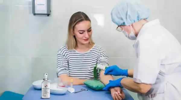 Pielęgniarka pobiera krew do badań, w tym **kreatynina na czczo**. Pacjentka spokojnie czeka na wynik.