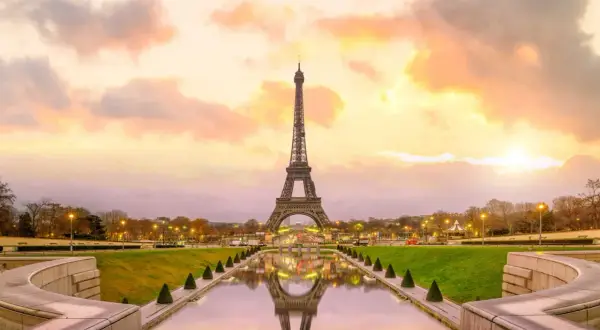Tour Eiffel au coucher du soleil, reflet dans l'eau. Pensez au prix billet tour eiffel pour une visite inoubliable.