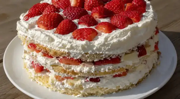 En vacker jordgubbstårta med fluffig grädde och saftiga jordgubbar. Perfekt att baka tårta till sommaren!
